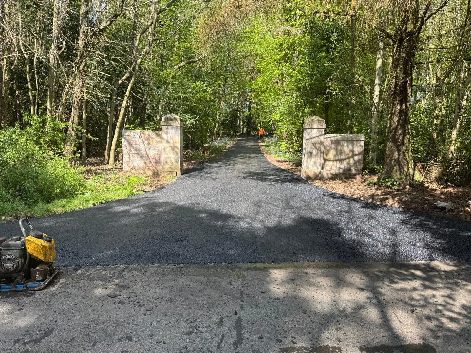 Freshly laid tarmac driveway through a stone-pillar estate entrance in East Lothian
