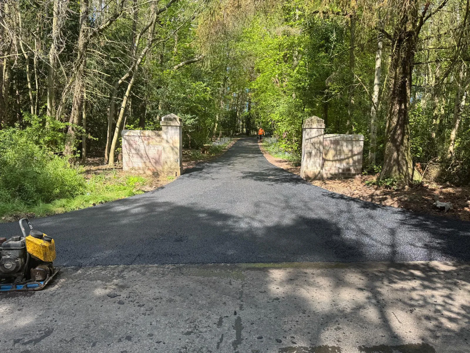 Freshly laid tarmac driveway through a stone-pillar estate entrance in East Lothian